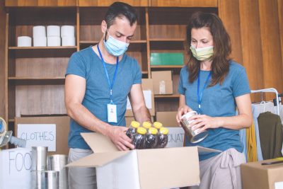 Volunteers working in charitable foundation Warehouse on helping homeless people.Social workers who provide humanitarian assistance to a disadvantaged person