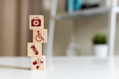 Wooden block with healthcare medical icons orange pastel background. stacking wooden cube box medical. healthcare treatment concept.